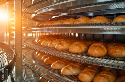 A lot of bread prepare to move on in the shelf. Bread bakery food factory production with fresh products. Automated production of bakery products.