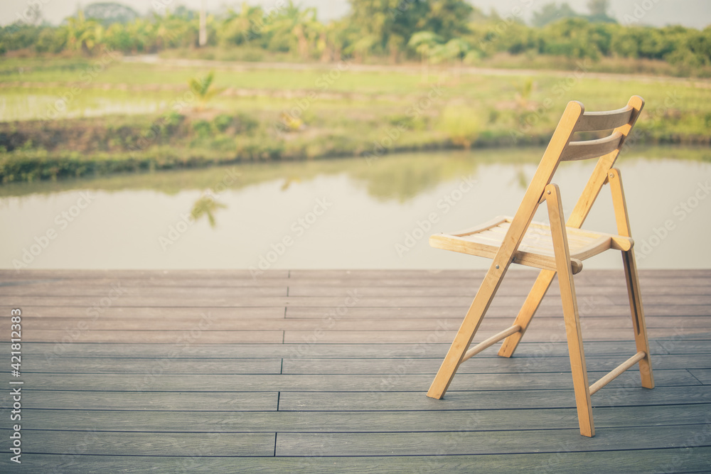 wooden chair on balcony terrace patio near pond - obrazy, fototapety, plakaty 