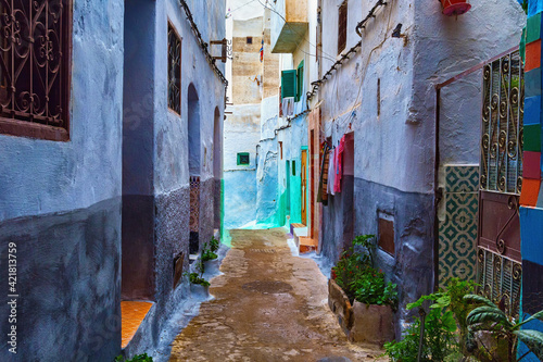 View of the old streets of Tetouan Medina quarter in Northern Morocco. A medina is typically walled, with many narrow and maze-like streets and often contain historical houses, palaces, places. © Renar