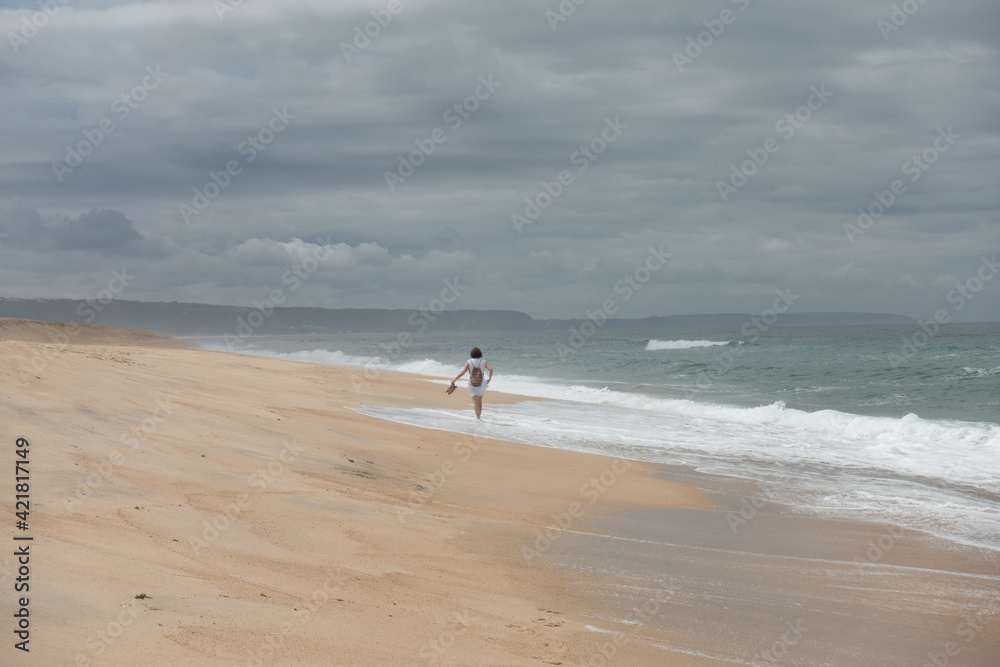 girl walking on an empty beach girl walking on an empty beach