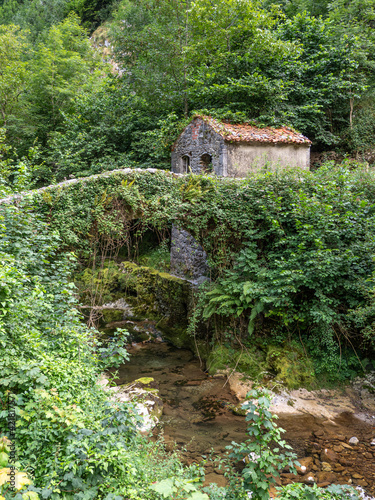 little house with river and stone bridge