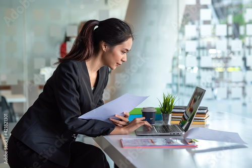 Φωτογραφία Asian businesswoman working in modern office using tablet and holding document