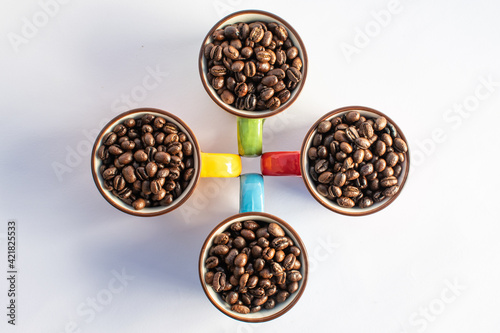 red, green, yellow, blue cups with coffee beans isolated