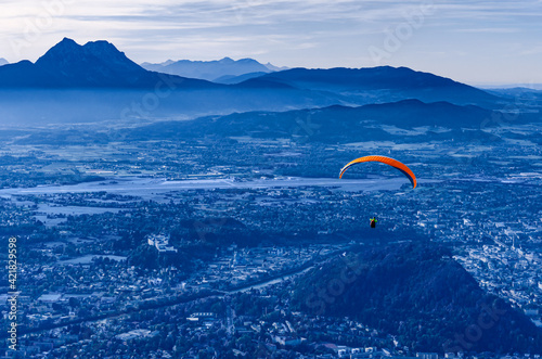 Paragliding over Salzburg in Austria, Europe. Paraglider, started from the 1287 meters high Gaisberg mountain, with view of capital city the State of Salzburg, and the fortress of Hohensalzburg. Photo © Peter Hermes Furian
