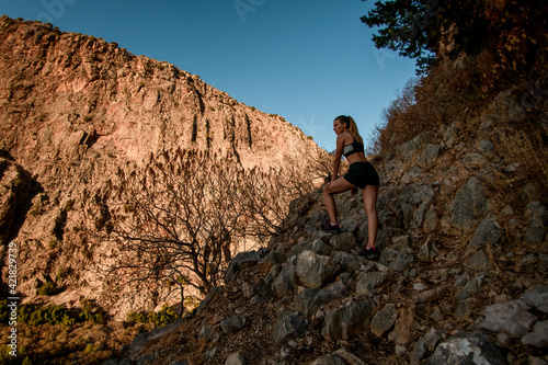 beautiful view of woman standing on rocky trail among mountains in Turkey