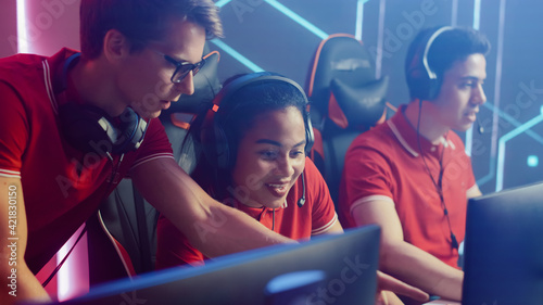 Diverse Esport Team of Pro Gamers Play in Video Game on a Championship, Talking Using Headsets, Trainer Explains Strategy. Stylish Neon Cyber Games Arena. International Tournament Event