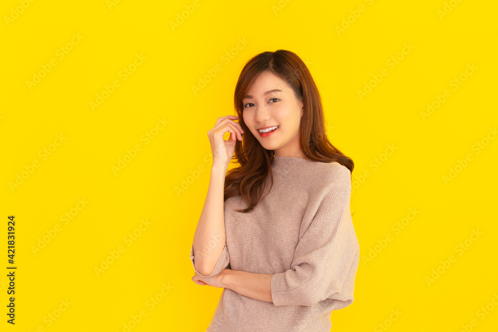 Beautiful Asian young woman's portrait on bright yellow background Beautiful Asian young woman's portrait on bright yellow background