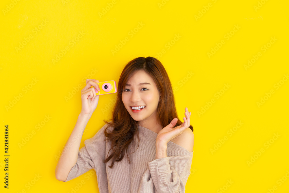 Beautiful Asian young woman's portrait on bright yellow background Beautiful Asian young woman's portrait on bright yellow background
