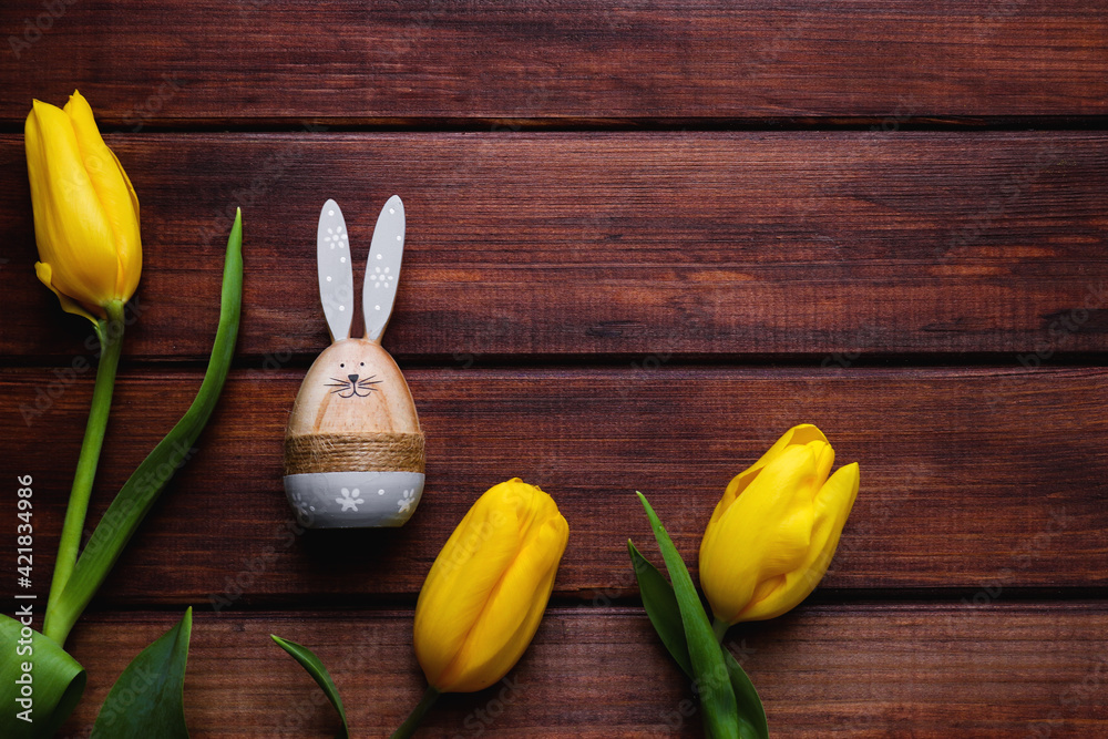 Easter composition with yellow tulips and Easter bunny on a rustic wooden background with copy space for congratulation. Top view, flat lay Easter composition with yellow tulips and Easter bunny on a rustic wooden background with copy space for congratulation. Top view, flat lay