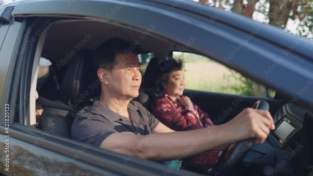 Asian family inside the car, middle aged father controlling a steering wheel on the driver seat, weekend activity family member get together, senior couple on the journey, retirement lifestyle Asian family inside the car, middle aged father controlling a steering wheel on the driver seat, weekend activity family member get together, senior couple on the journey, retirement lifestyle