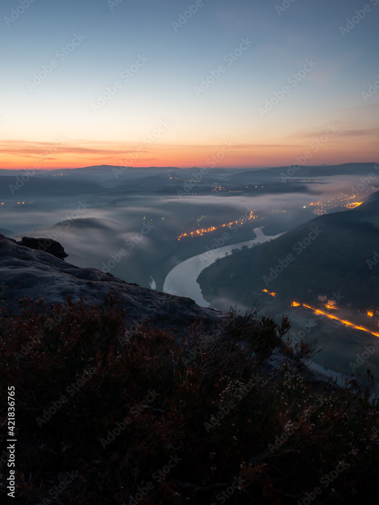 Sunrise in the morning at the Saxon Switzerland with a beautiful view in the valley. Golden sunlight shining in the landscape.
