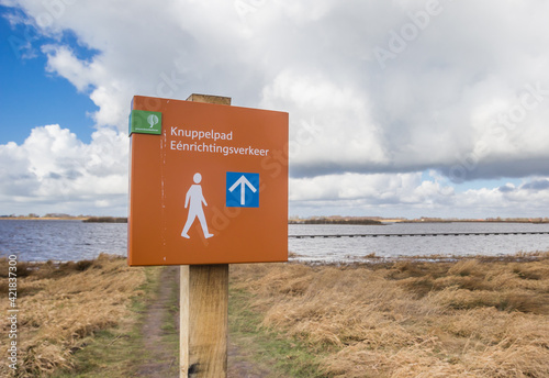 Sign for the one way Knuppelpad walking path over the lake in Roegwold, Netherlands photo