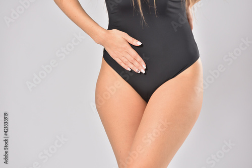 Woman holding her lower abdomen in pain, concept of female health