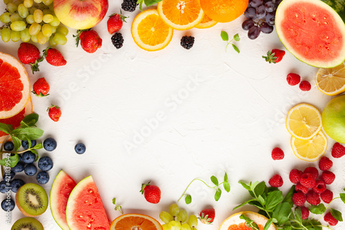 Assorted fresh fruits and berries on white background. Clean eating food, healthy life. Top view.