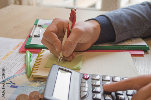 savings, finances, economy and home concept - close up of man with calculator counting money and making notes