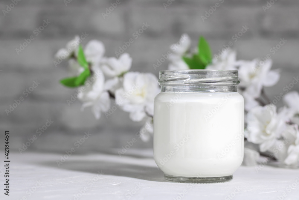 Organic probiotic milk kefir drink or Greek yogurt in glass jar,on the white grey background. Gut health. Probiotic cold fermented dairy drink. Trendy food and drink. Copy space Organic probiotic milk kefir drink or Greek yogurt in glass jar,on the white grey background. Gut health. Probiotic cold fermented dairy drink. Trendy food and drink. Copy space