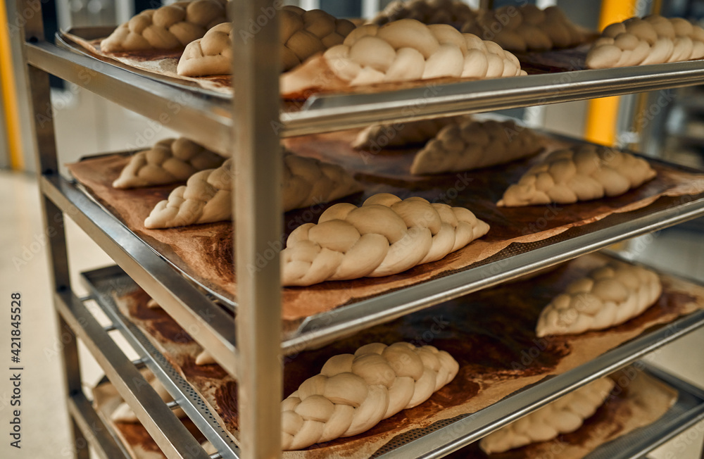 Bread on the shelves is being prepared for baking in the oven. Production of bakery products. Bread baking factory.