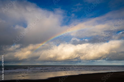 The beach at Seaside on the Oregon coast with clouds and rainbow