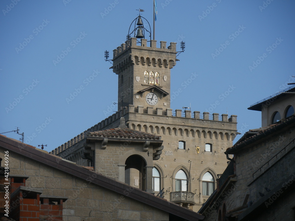 San Marino, Public Palace. Closeup on the crenellated clock tower with the mosaic and the coats of arms of the four Castles of the Republic