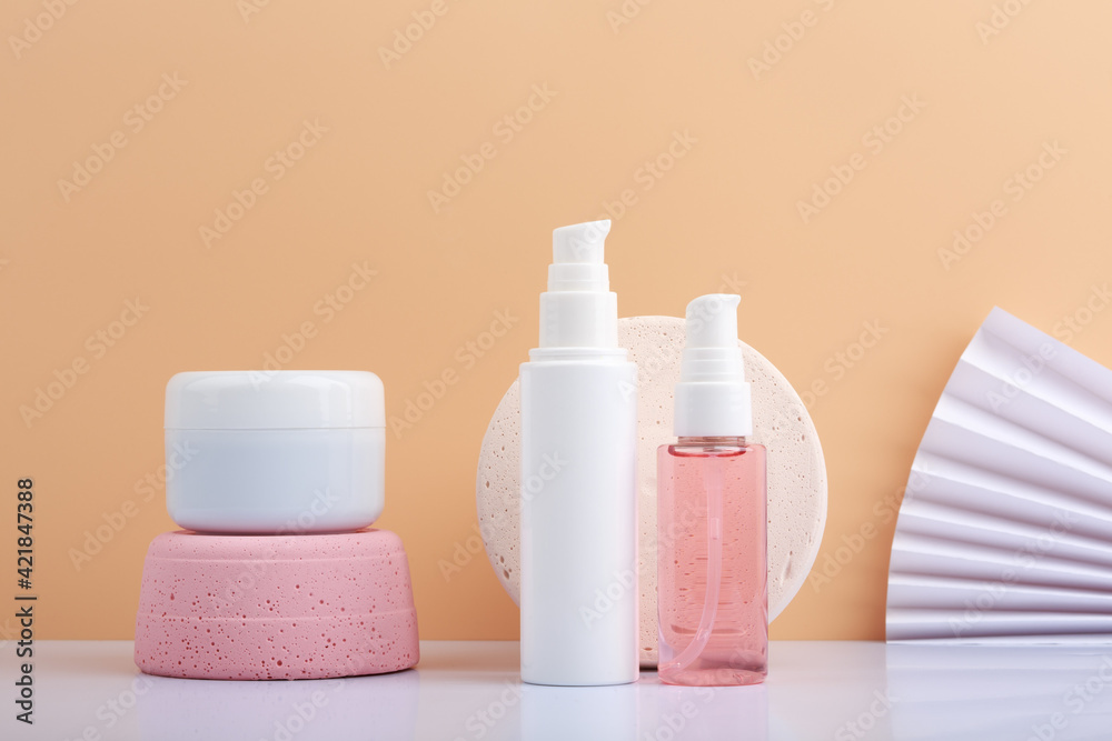 Set for skin care against beige background decorated with waver. Face cream, scrub or mask, lotion and cleaning and exfoliating foam Set for skin care against beige background decorated with waver. Face cream, scrub or mask, lotion and cleaning and exfoliating foam