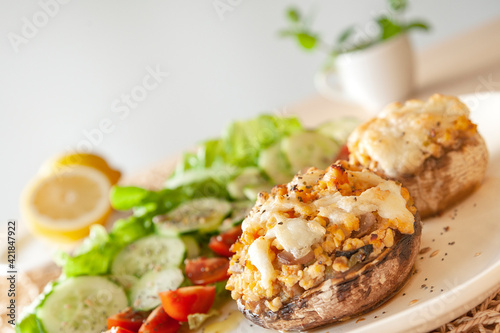 Mediterranean food. Stuffed mushrooms whith cheese, salad, tomato, cucumber, lemon.