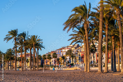 View of the colorful houses of the town of Villajoyosa from its beach at sunrise.