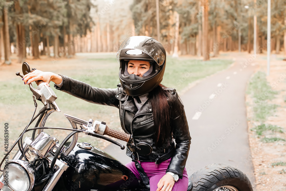 Obraz premium beautiful brunette riding a motorcycle in the park