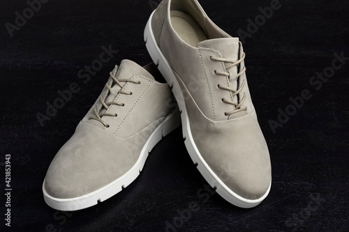 Fashionable women's shoes, gray with white soles on a black background. Close-up
