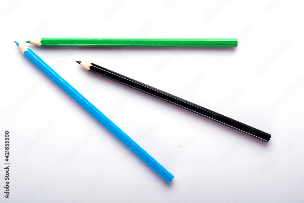 Various colored wooden pencil crayons placed in a row in front of a white isolated background Various colored wooden pencil crayons placed in a row in front of a white isolated background