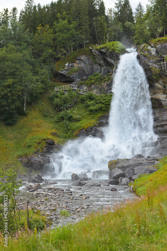 Steinsdalfossen Waterfall. Norway. Summer. Waterfall among the forest on the rocks