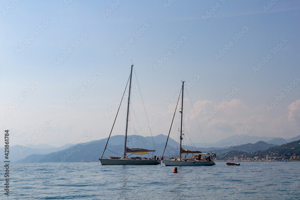Yachts in the sea against the backdrop of mountains and the city.