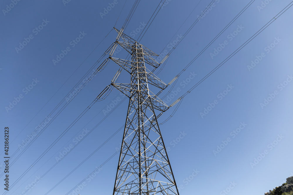 metallic electrical tower with parallel cables divides the blue sky metallic electrical tower with parallel cables divides the blue sky