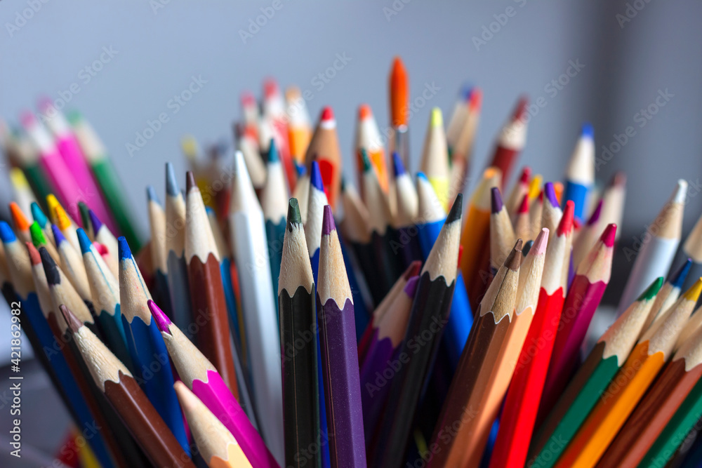 A large set of colored pencils, standing on the table in a stand. A large set of colored pencils, standing on the table in a stand.