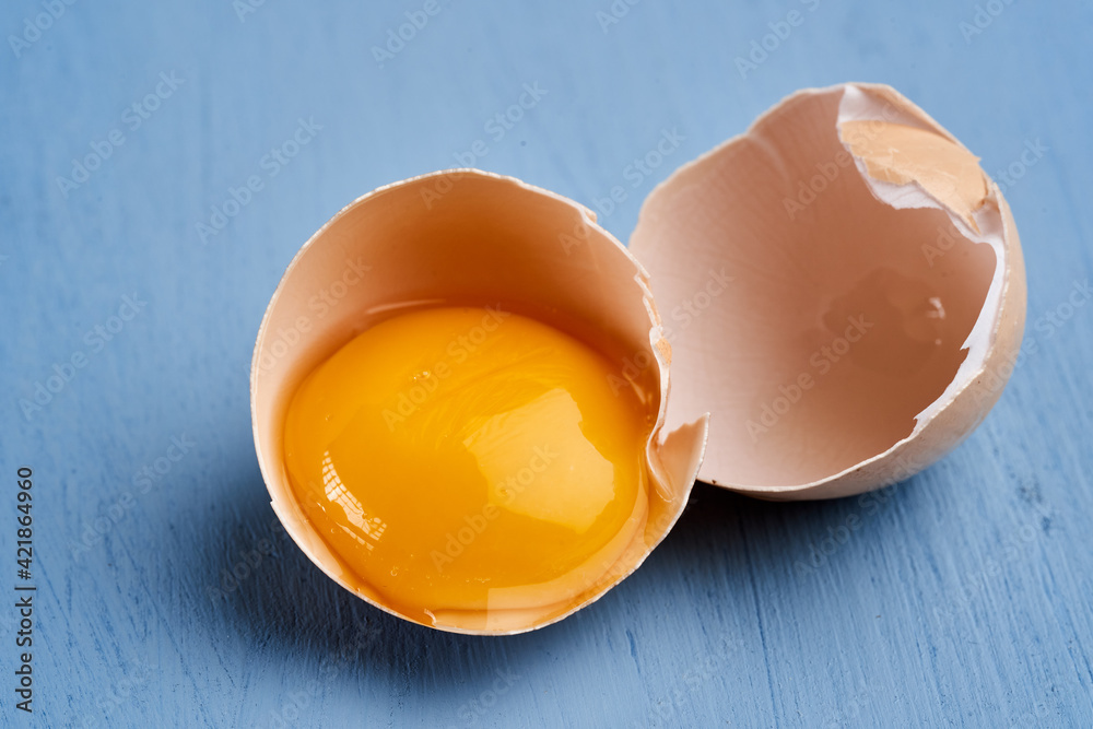 Egg in broken shell on blue