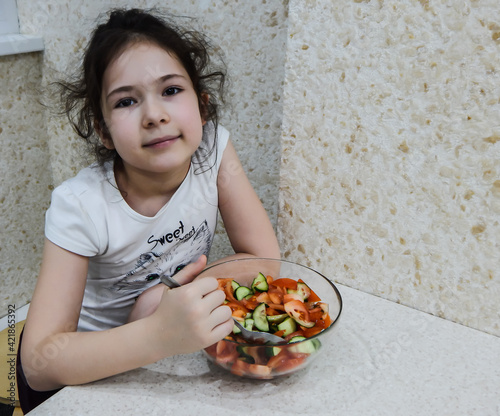 girl mixed saland of tomatoes and cucumbers photo