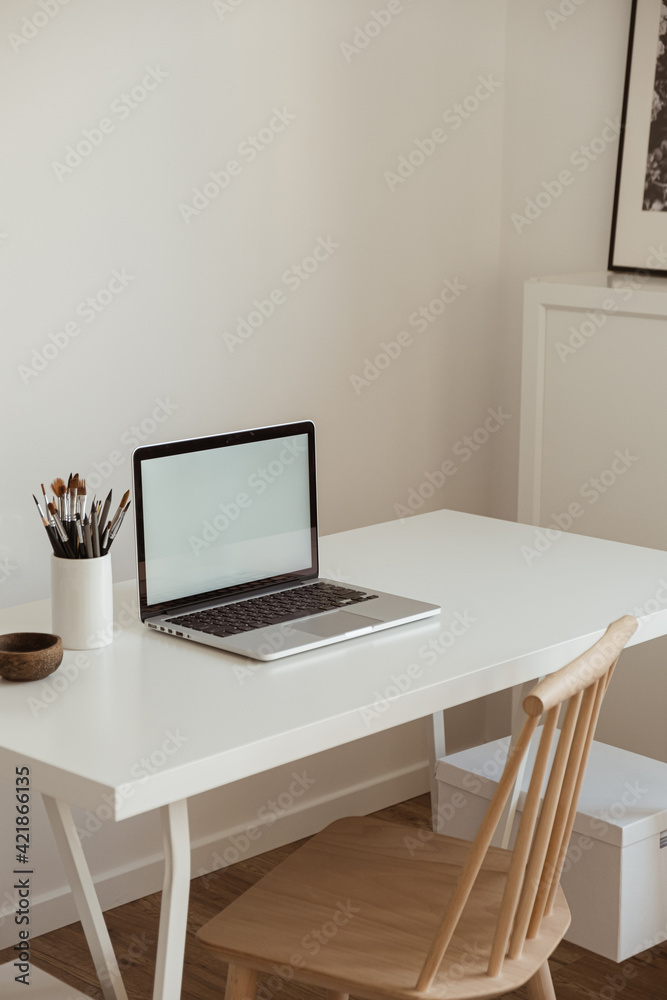 Laptop with blank copy space screen on table with stationery on table against white wall. Minimalist home office workspace. Mockup template. Laptop with blank copy space screen on table with stationery on table against white wall. Minimalist home office workspace. Mockup template.