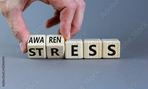 Stress awareness symbol. Businessman turns cubes and changes the word 'stress' to 'awareness'. Beautiful grey background. Business, psychological and stress awareness concept. Copy space.