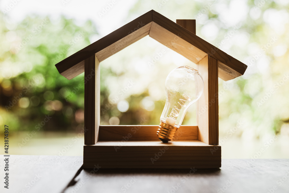 Light bulb with wood house on the table, a symbol for construction,  Creative light bulb idea, power energy or business idea concept ecology,  loan, mortgage, property or home. Photos | Adobe Stock