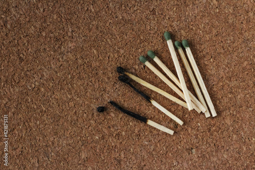 Burnt and  whole green matches on a cork background. Close-up 