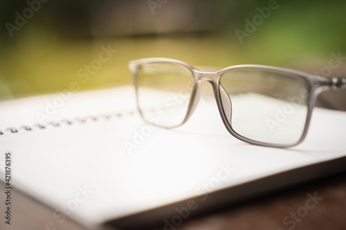 Classic eye glasses on white notebook, idea, innovation and inspiration concepts.