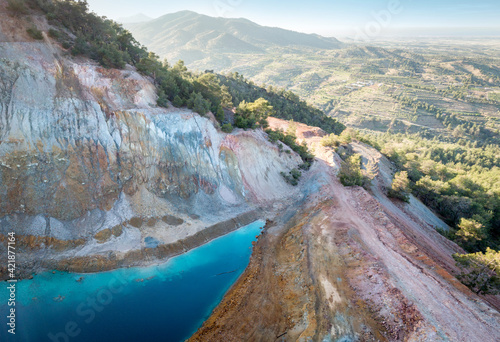 Aerial view of abandoned opencast Alestos mine in Cyprus. Blue lake and colorful rocks rich of copper and sulfide deposits photo