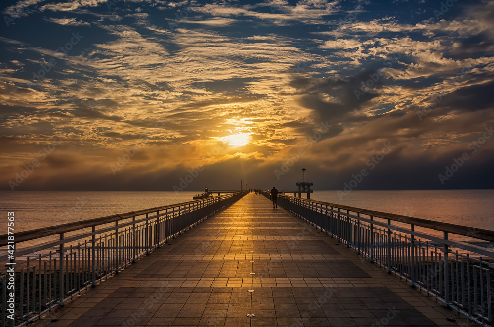 Dramatic sunrise on the beach in Burgas, Bulgaria. Sunrise on the Burgas Bridge. Bridge in Burgas - symbol of the city.