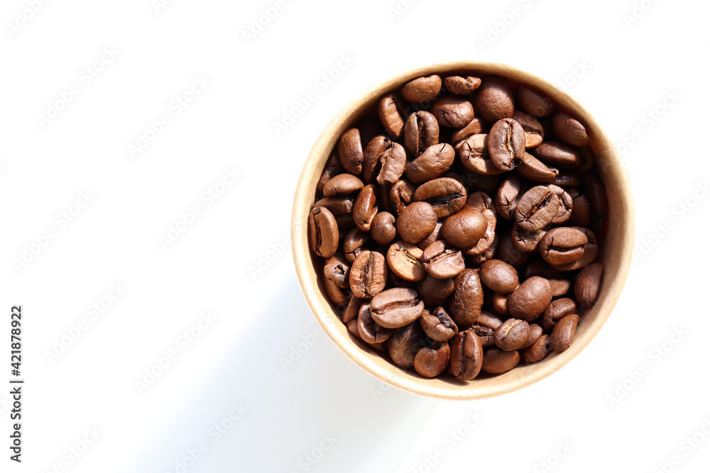 Roasted coffee beans in a kraft paper cup. Top view, copy space