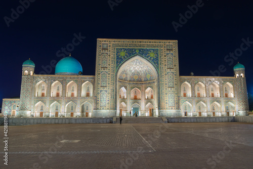 Tilya-Kori Madrasah at night  in the Registan, ancient city of Samarkand in Uzbekistan. Iwan and spandrel with ceramic tiles in Tilya Kari Madrassa. photo