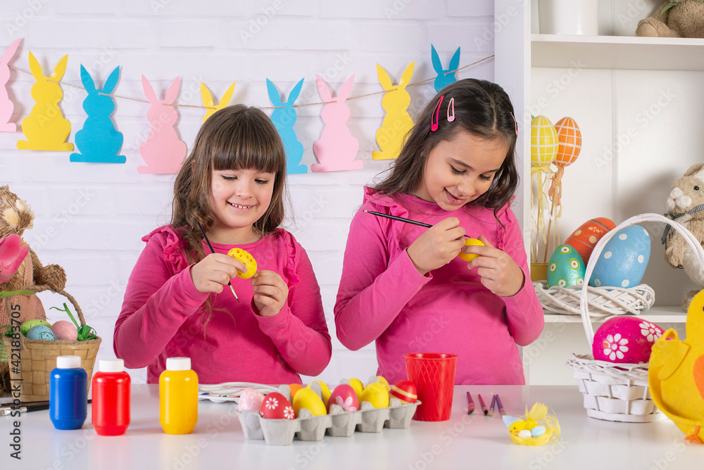 Happy Easter! Two cute little creative girls are painting eggs hare getting ready for holiday
Happy Easter! Two cute little creative girls are painting eggs hare getting ready for holiday