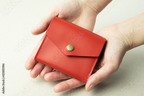 bright red leather wallet in female hands close-up