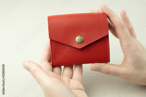 bright red leather wallet in female hands close-up