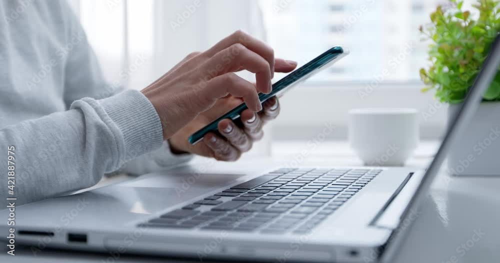 Woman's hands use mobile phone and laptop to shop online. Authentication in Internet banking on a smartphone and computer. Slow motion 4k.