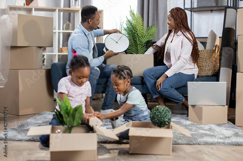 Young african family sitting at new flat with boxes