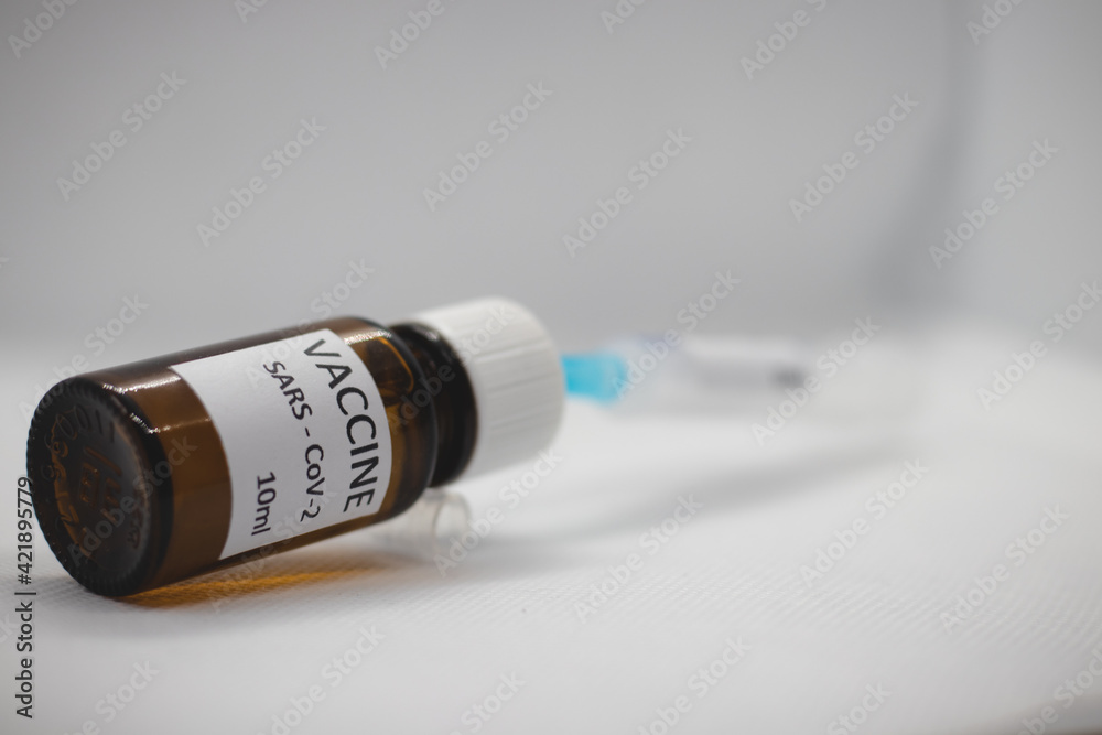 Close-up medical syringe with a vaccine. Vaccine ampoule full of anti-virus medicine, ready for vaccination. A coronavirus pandemic. Vaccination phase. Coverage protection 19 Close-up medical syringe with a vaccine. Vaccine ampoule full of anti-virus medicine, ready for vaccination. A coronavirus pandemic. Vaccination phase. Coverage protection 19